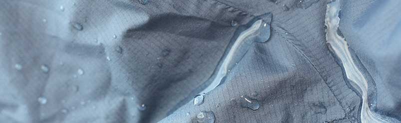Bild på impregnerat tyg med vattendroppar.