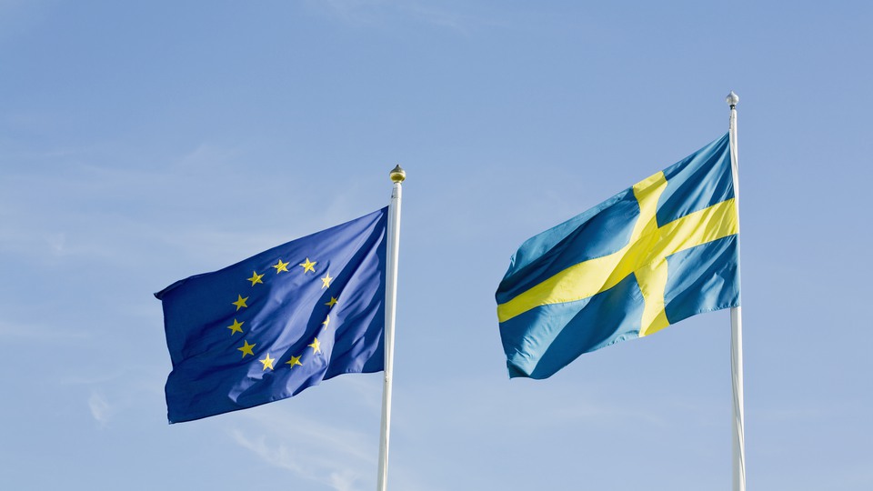 EU-flaggan och den svenska flaggan mot en blå himmel.