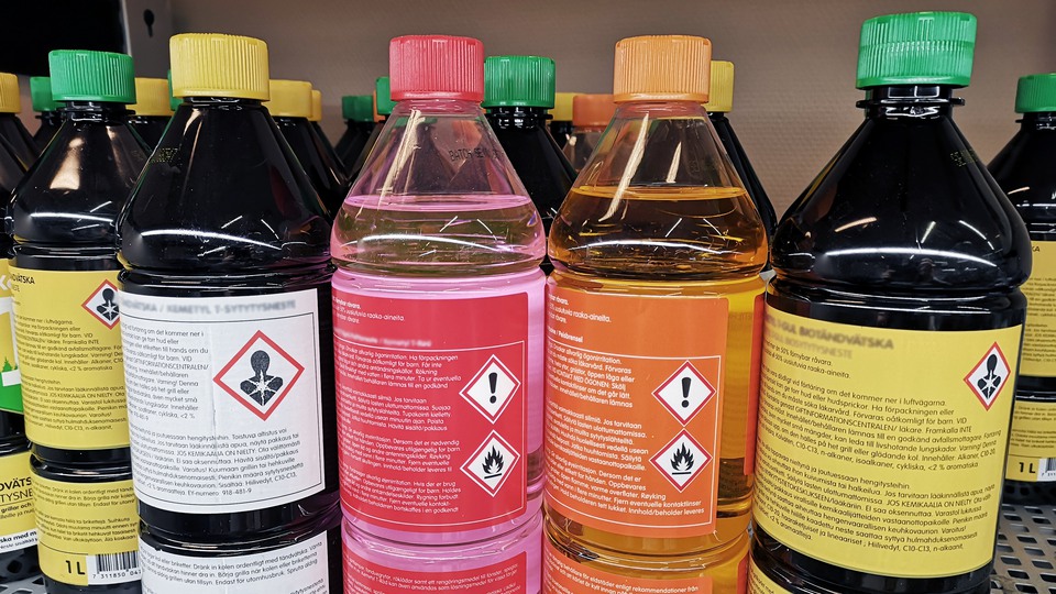 Flera flaskor med kemiska produkter på en butikshylla.