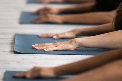 Händer på yogamatta
